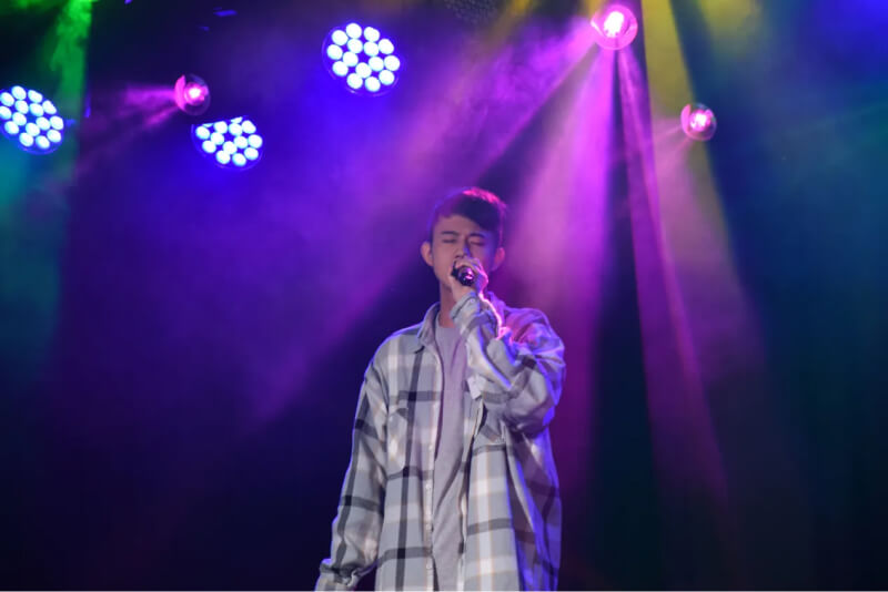 Closeup shot of Guo singing to a microphone