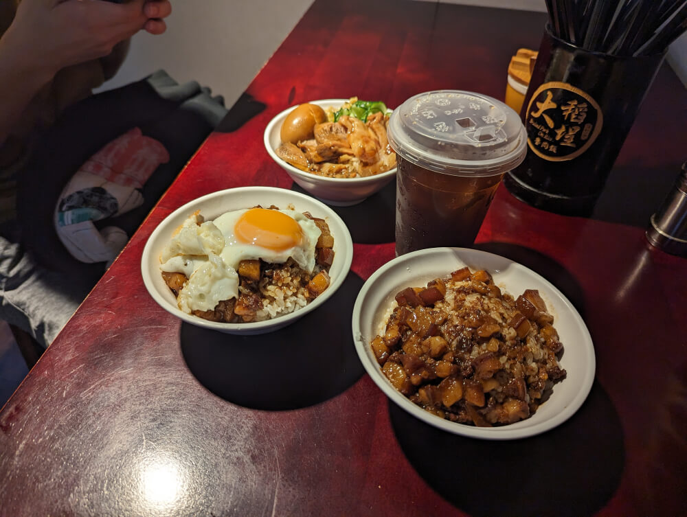 Three bowls of braised pork over rice and a cup of ice tea